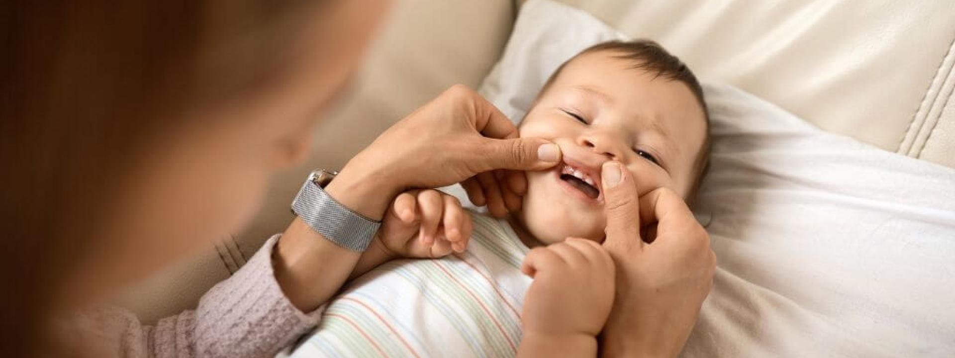 Mother inspecting child's teeth coming in 